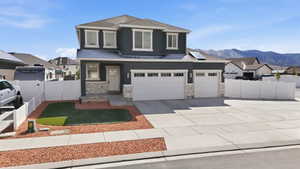 View of front facade with driveway, a residential view, stucco siding, roof with shingles, and stone siding