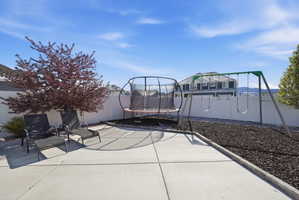 Fenced backyard featuring a trampoline