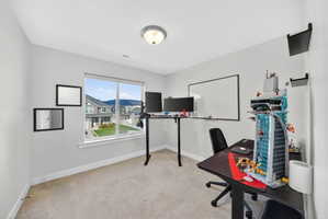 Home office featuring light colored carpet and baseboards