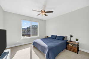 Bedroom with light carpet and a ceiling fan