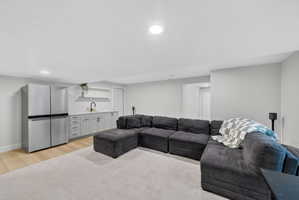 Living room featuring wet bar and light wood finished floors
