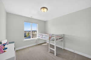 Bedroom featuring light carpet and baseboards