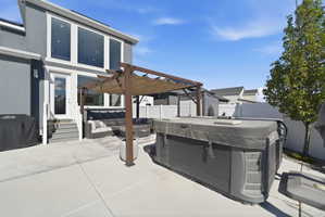 Fenced backyard featuring a pergola, outdoor furniture, and a hot tub