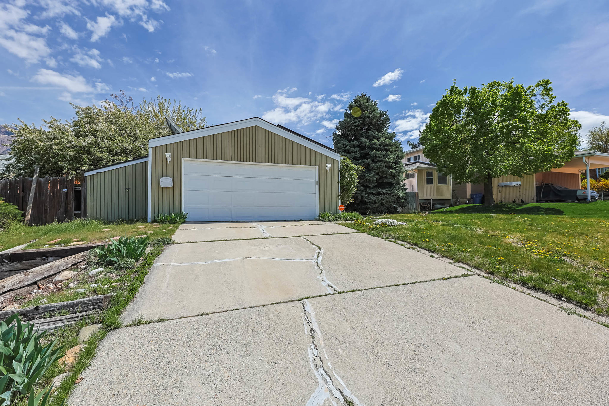 View of front of property featuring a garage, an outdoor structure, and a front yard