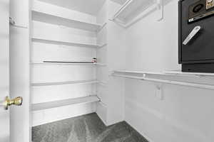 Walk in closet with dark colored carpet
