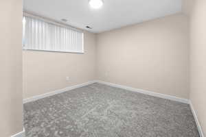 Unfurnished room featuring carpet floors and a smoke detector