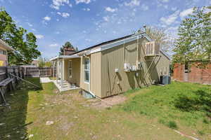Rear view of property with solar panels, a chimney, and a fenced backyard