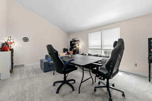 Office area with light carpet and lofted ceiling
