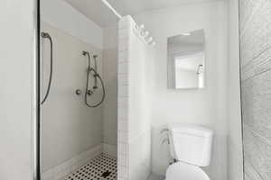 Full bath featuring a stall shower and tile walls