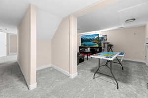 Playroom featuring light colored carpet and vaulted ceiling