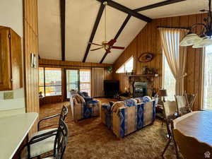Carpeted living area featuring wood-burning fireplace