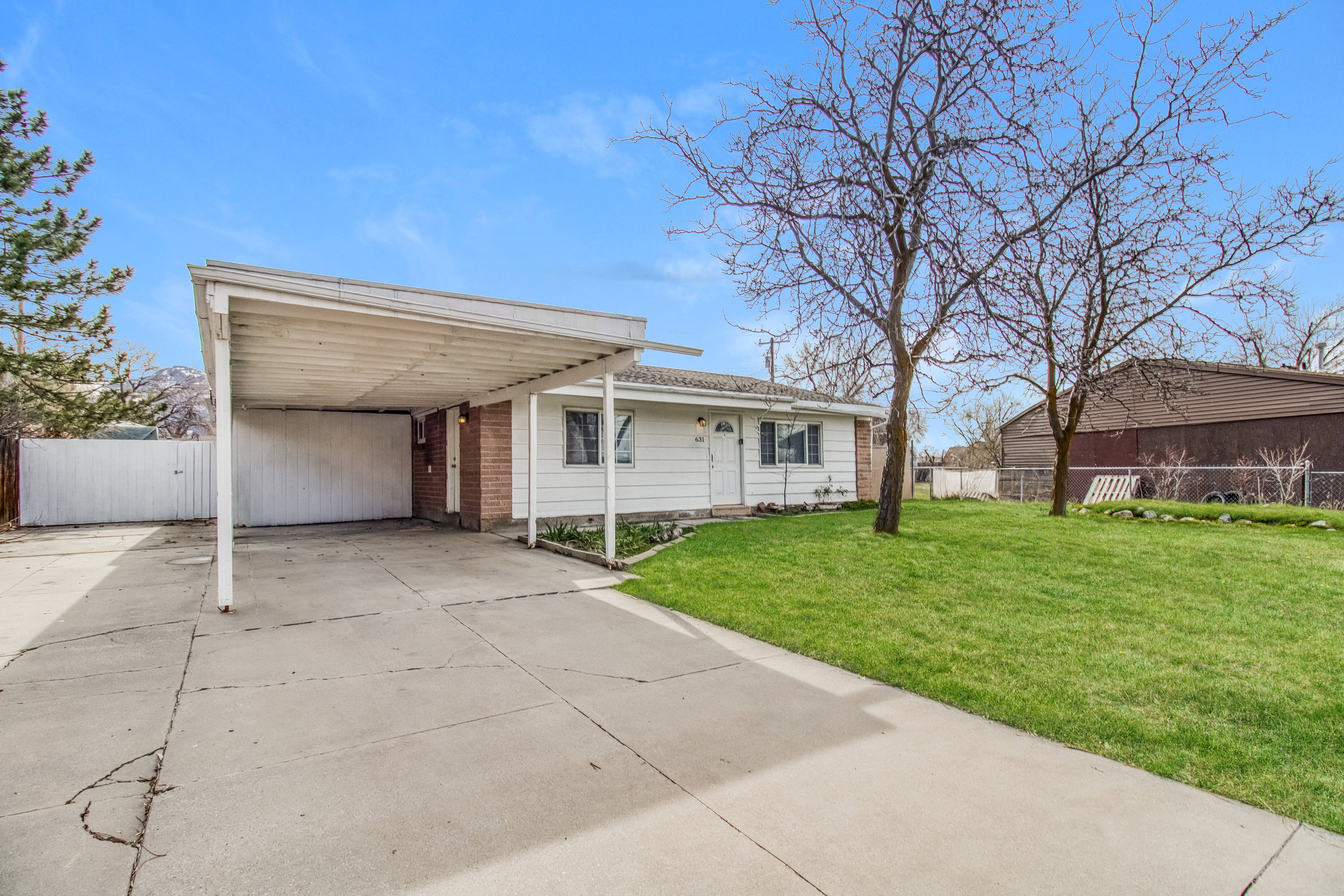 View of front of house featuring concrete driveway and an attached carport
