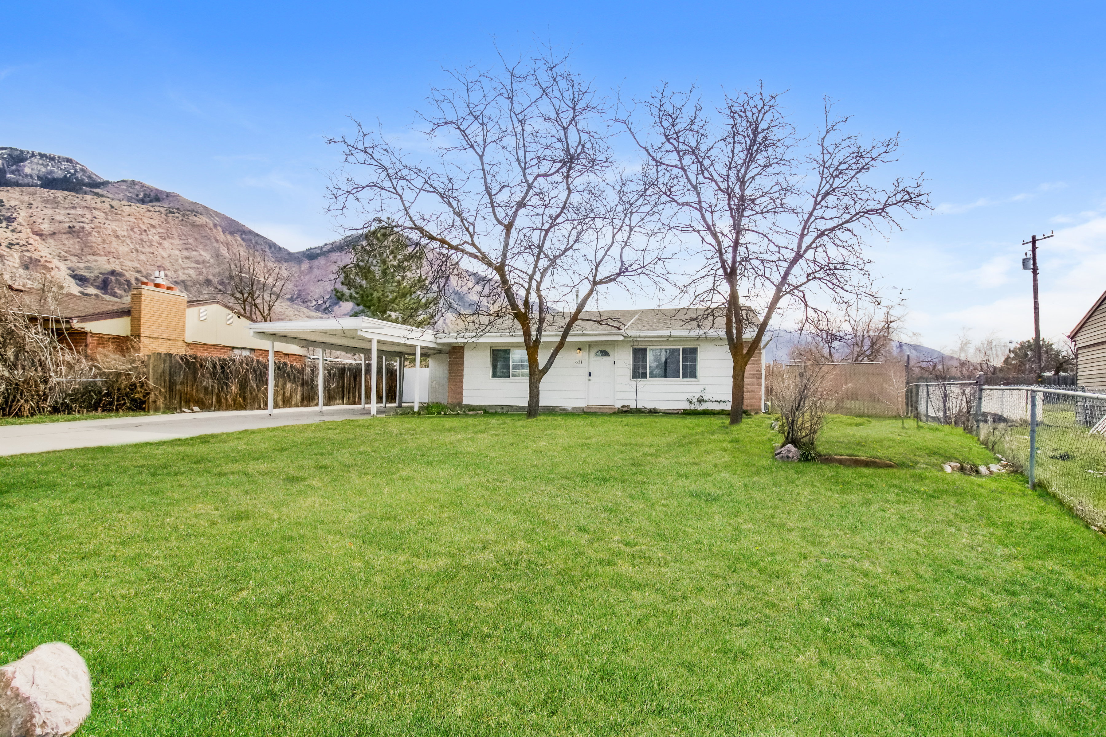 View of front facade with a carport, driveway, and a mountain view