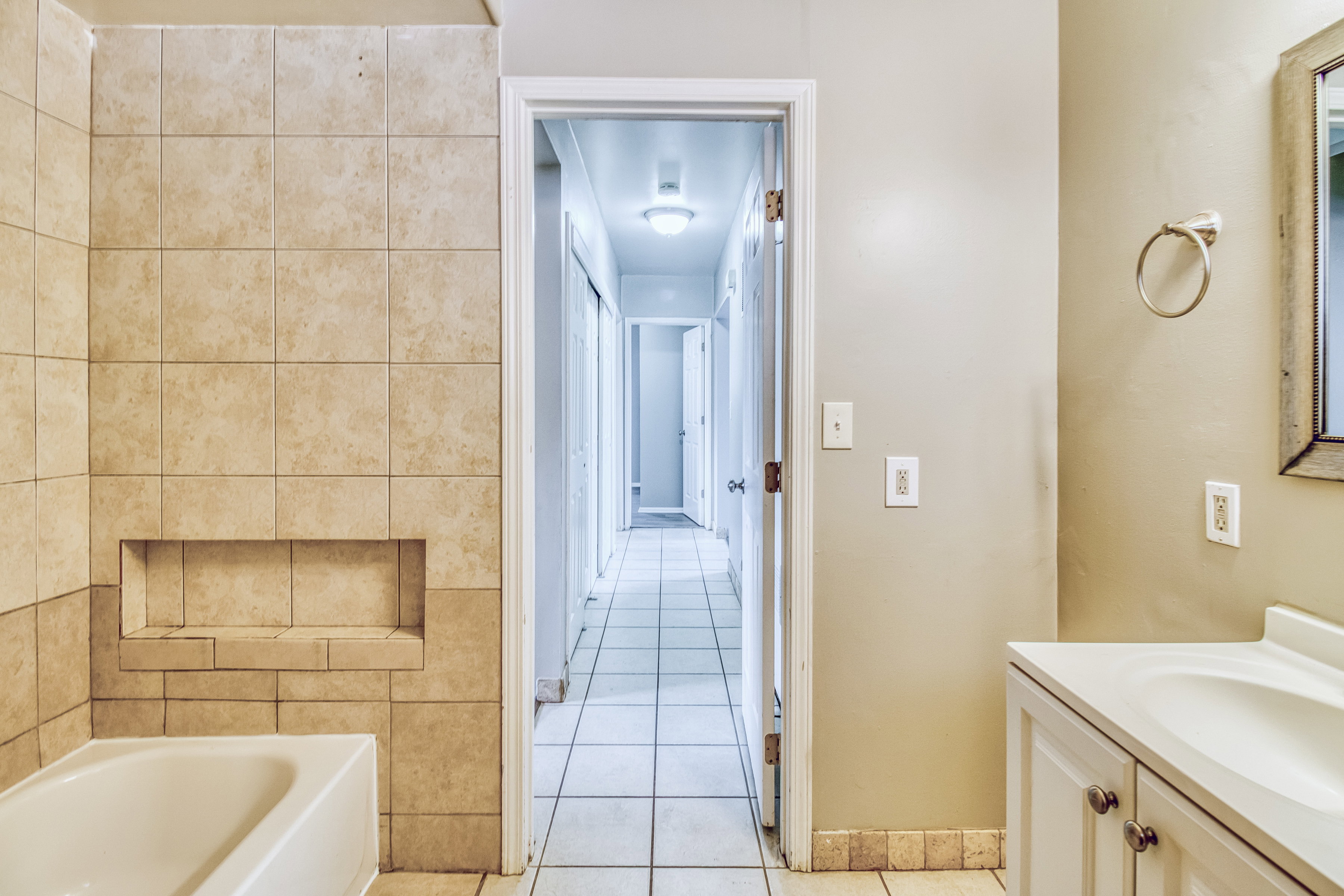 Bathroom with vanity, light tile patterned floors, and tile walls