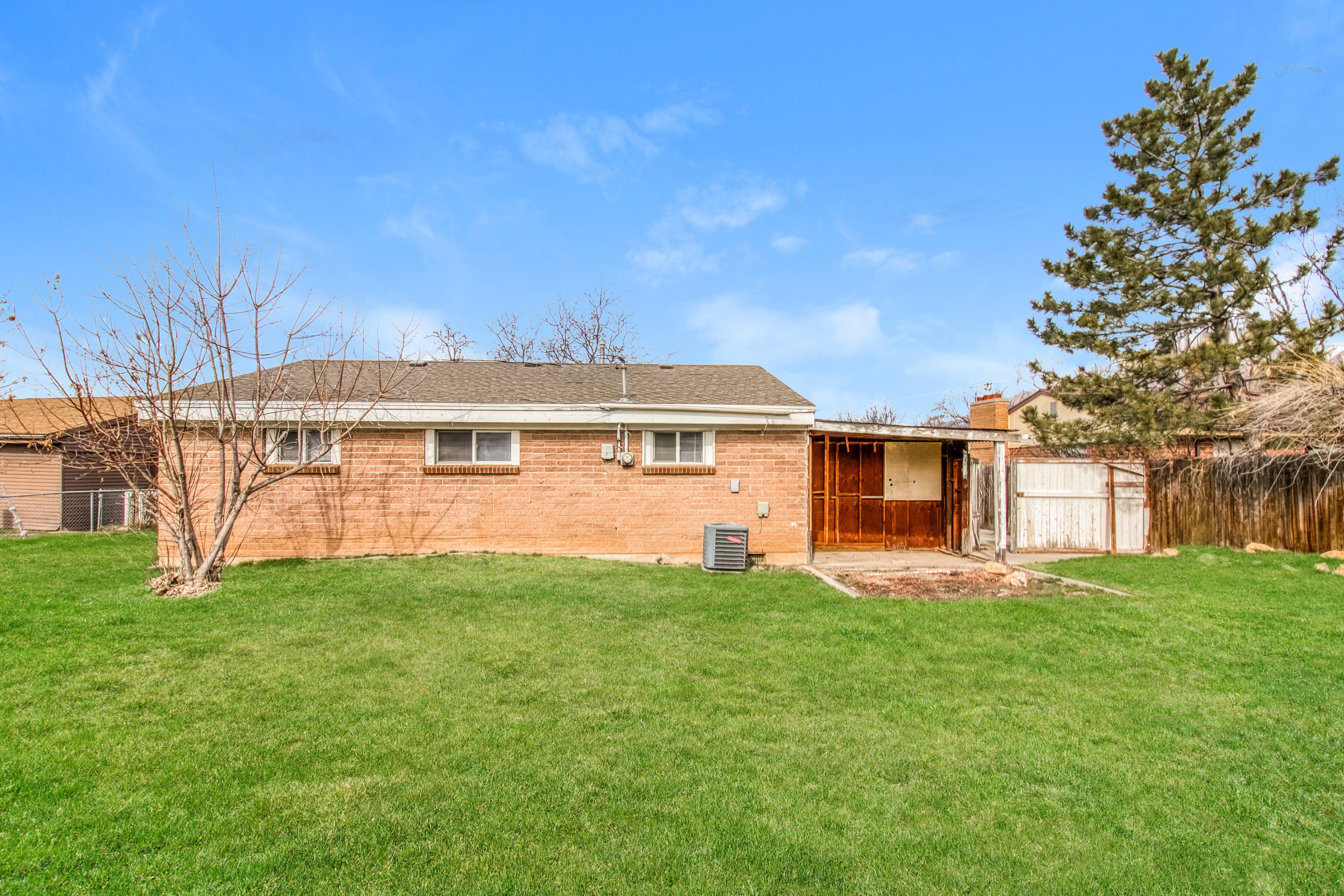 Rear view of house with a patio, a fenced backyard, and brick siding