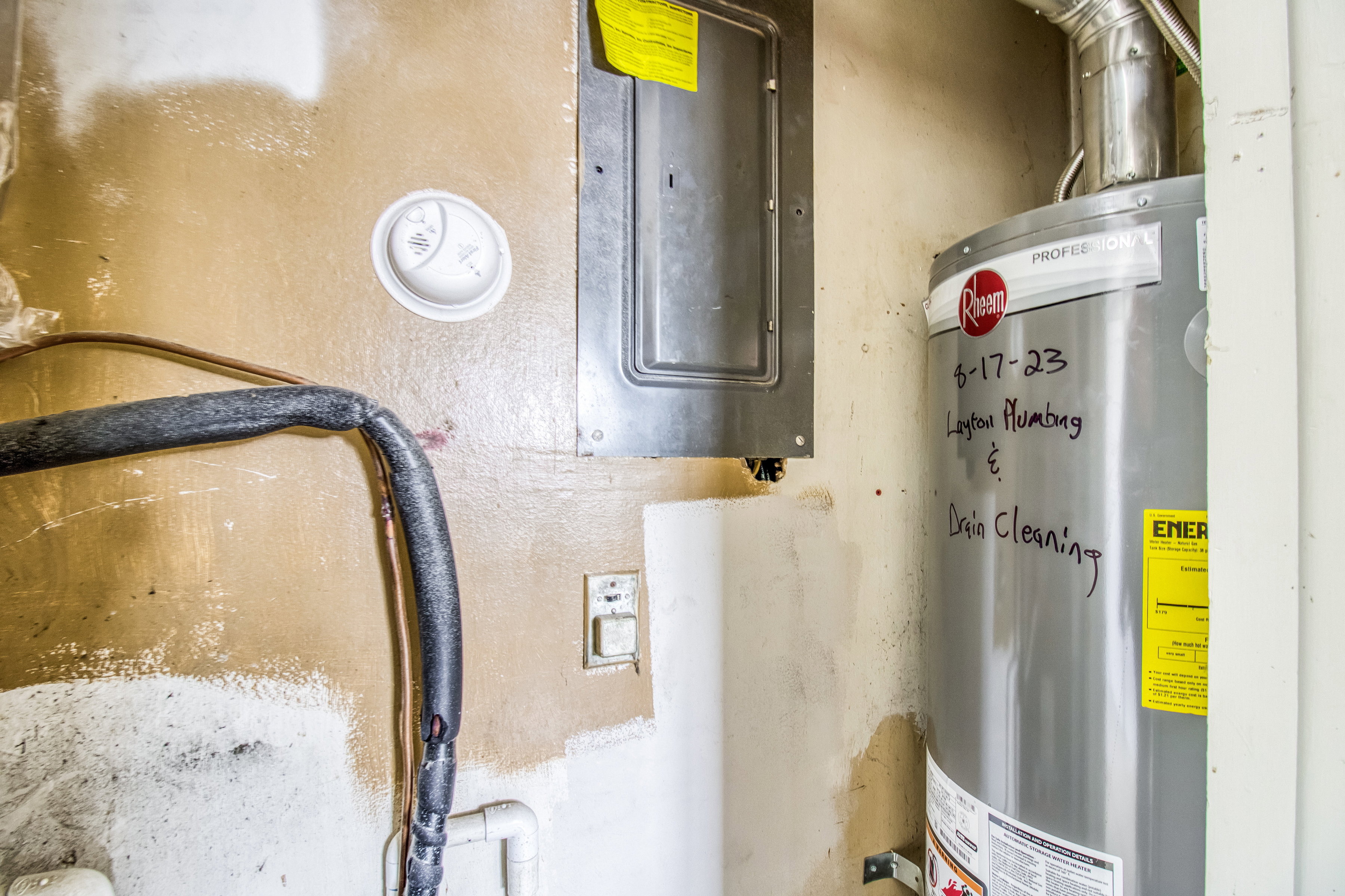 Utility room featuring gas water heater and electric panel