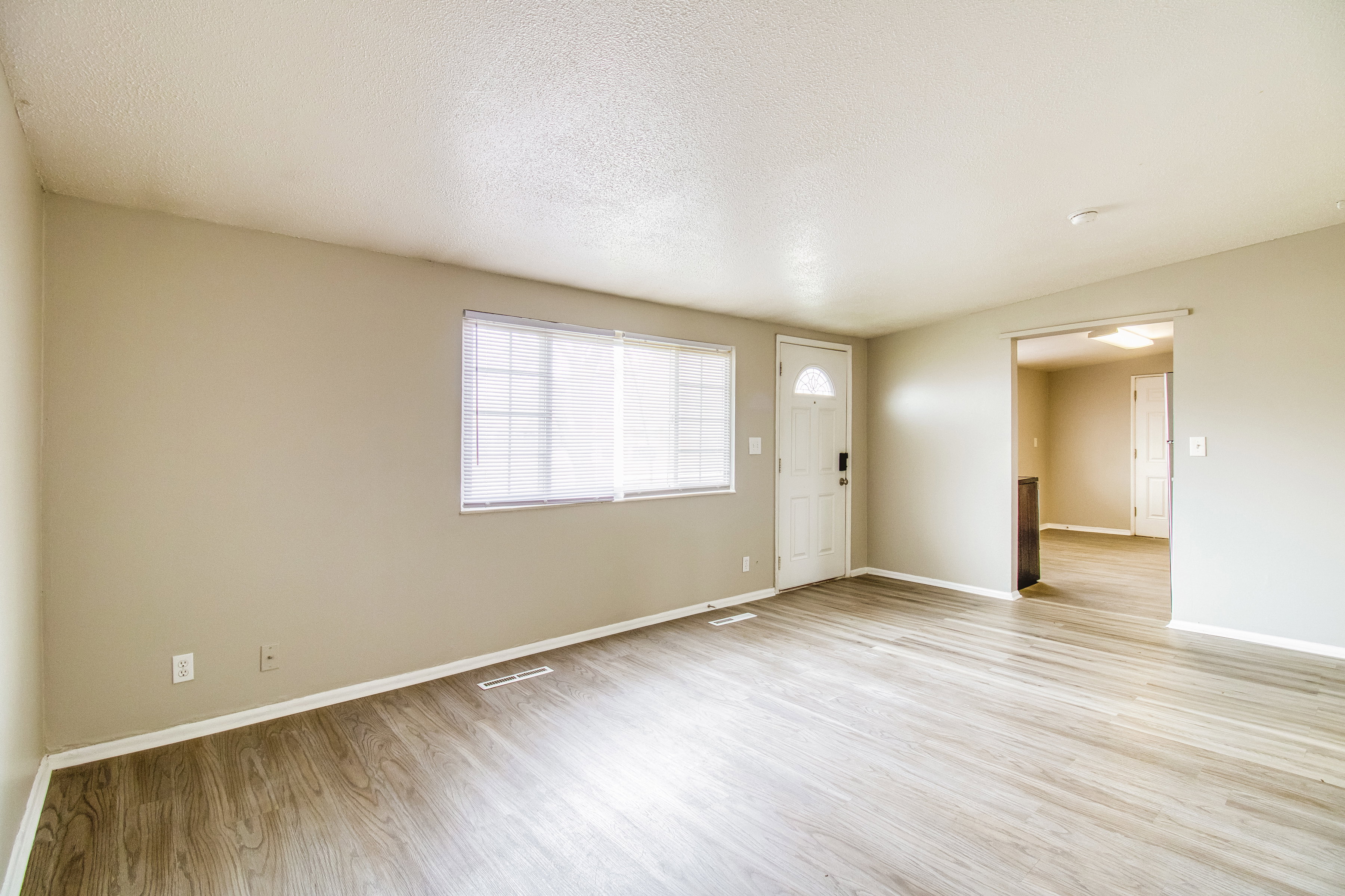 Spare room featuring light wood-type flooring and a textured ceiling