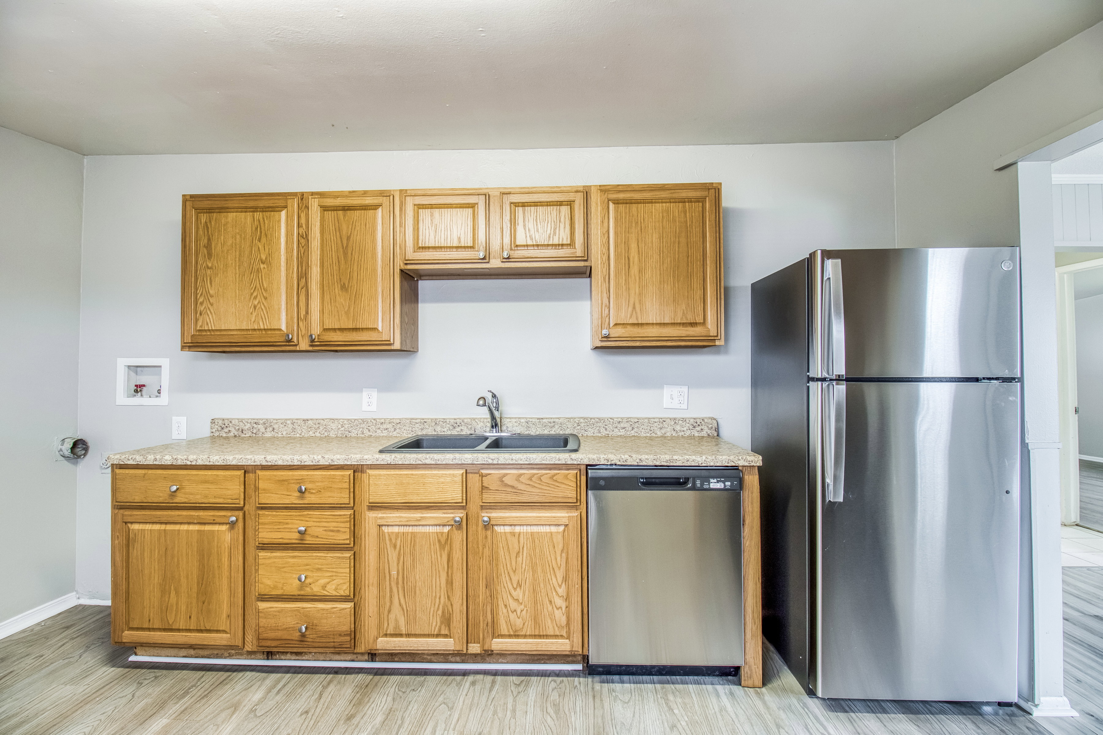 Kitchen featuring stainless steel appliances, wood finish cabinets, and light wood-style floors