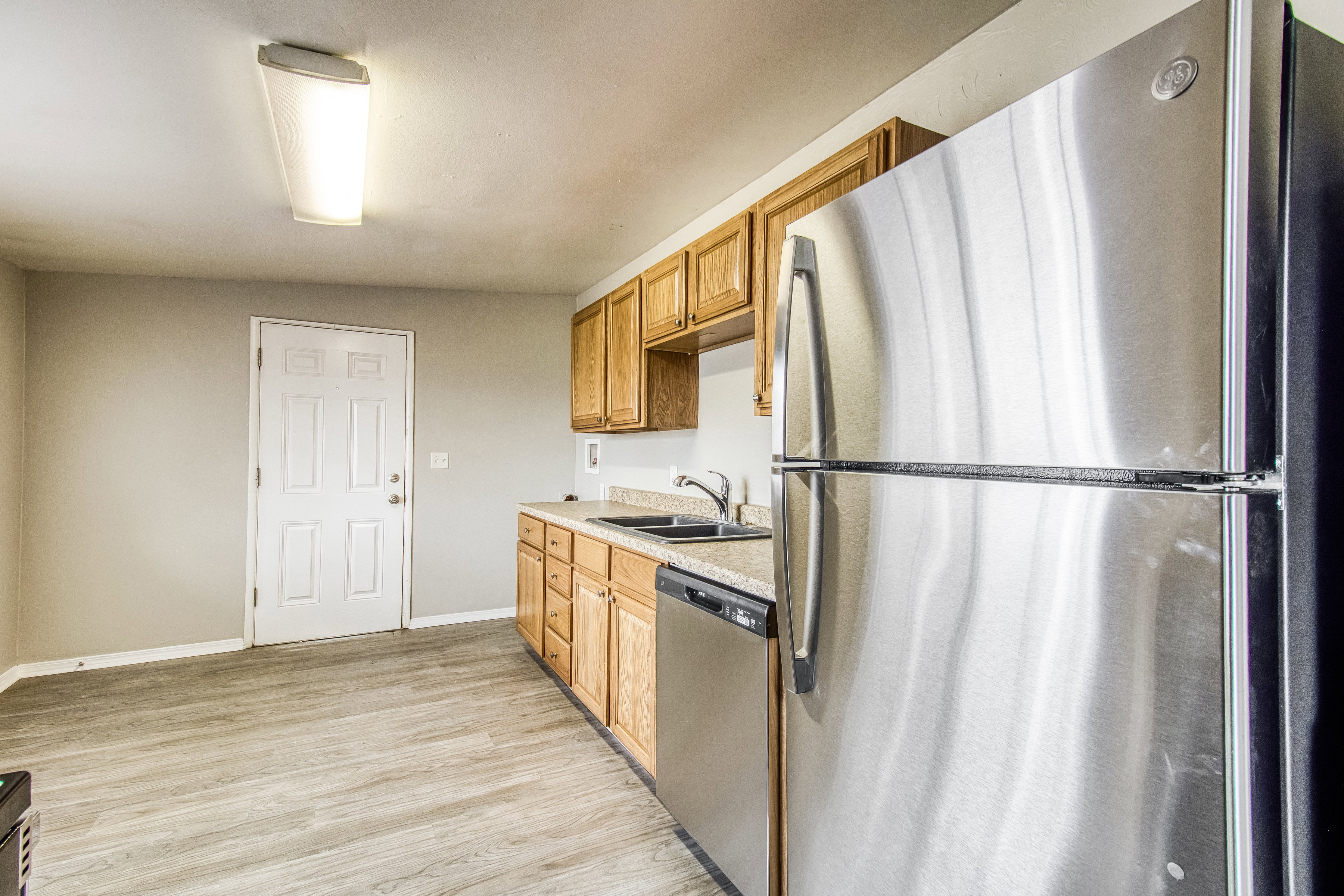 Kitchen with stainless steel appliances, light countertops, and light wood-style floors