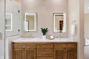Full bath featuring tile walls, double vanity, and a shower stall