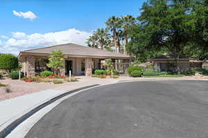 View of front of home with a tile roof, stone siding, and a gate