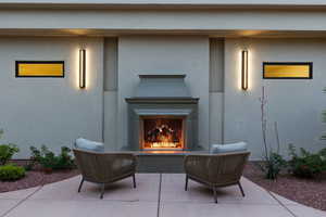 View of patio / terrace featuring a lit fireplace