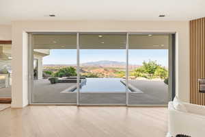 Doorway to outside featuring a mountain view, wood-type flooring, and plenty of natural light
