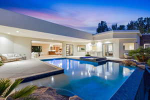 Relaxing pool / spa with a patio area, grilling area, and outdoor furniture