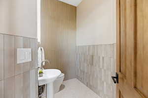 Bathroom with tile walls and speckled floor