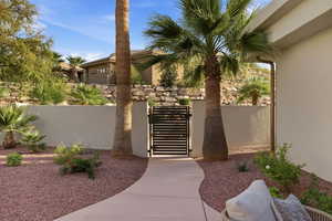 View of exterior entry with a gate and stucco siding