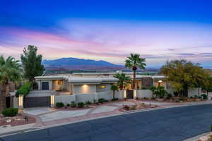 View of front of house featuring a gate, a fenced front yard, stucco siding, a mountain view, and driveway