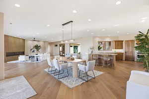 Dining area with light wood finished floors and recessed lighting