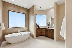 Full bath with vanity, a soaking tub, and recessed lighting