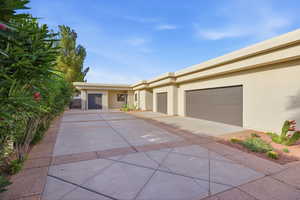 View of front of property featuring stucco siding, driveway, and an attached garage
