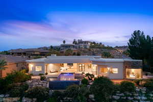 Rear view of house featuring stucco siding, a patio, and an outdoor pool