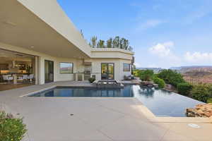 Combined pool / hot tub with a patio area and area for grilling
