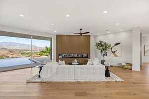Living area with light wood-type flooring, a mountain view, ceiling fan, and recessed lighting