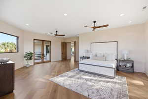 Bedroom featuring french doors, light wood finished floors, access to outside, recessed lighting, and multiple windows