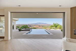 View of patio / terrace with a mountain view, an in-ground hot tub, and grilling area