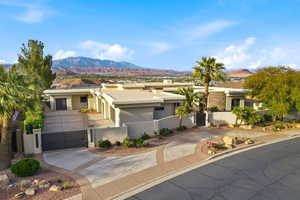 View of front of property with a gate, stucco siding, a mountain view, driveway, and a fenced front yard