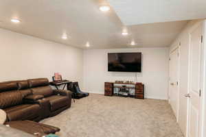 Living area featuring light colored carpet, recessed lighting, and a textured ceiling