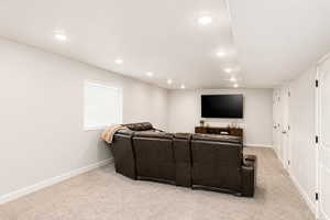 Home theater/family room  featuring recessed lighting and light carpet