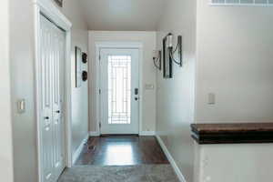 Entryway with baseboards and wood finished floors