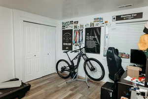 Bedroom/office featuring wood finished floors and a closet