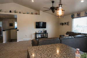 Carpeted living room with a ceiling fan and recessed lighting