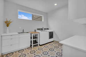Laundry area with cabinet space, light flooring, washer and dryer, and recessed lighting