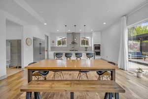Dining area with light wood-style floors and recessed lighting