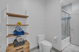 Bathroom featuring toilet and enclosed tub / shower combo