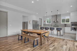 Dining room with light wood finished floors and recessed lighting