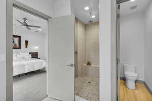 Ensuite bathroom with recessed lighting, a tile shower, ceiling fan, and light colored carpet